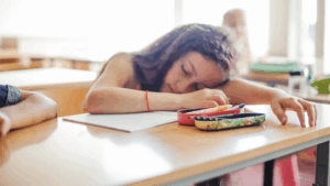girl with her head down on a table sleeping